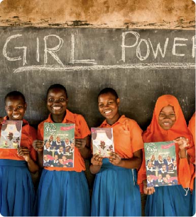 Girls standing in a row holding up literature